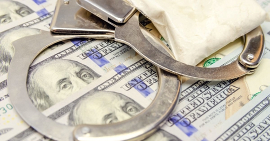 handcuffs and a bag of drugs on dollar bills