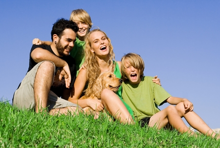 Family of four laughing outdoors