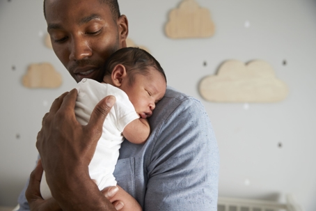 a father holding a baby in the nursery