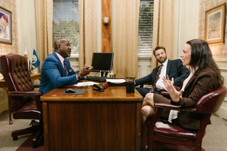 two gentleman and a woman sitting in an office